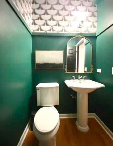 A bathroom with a toilet a sink and a mirror