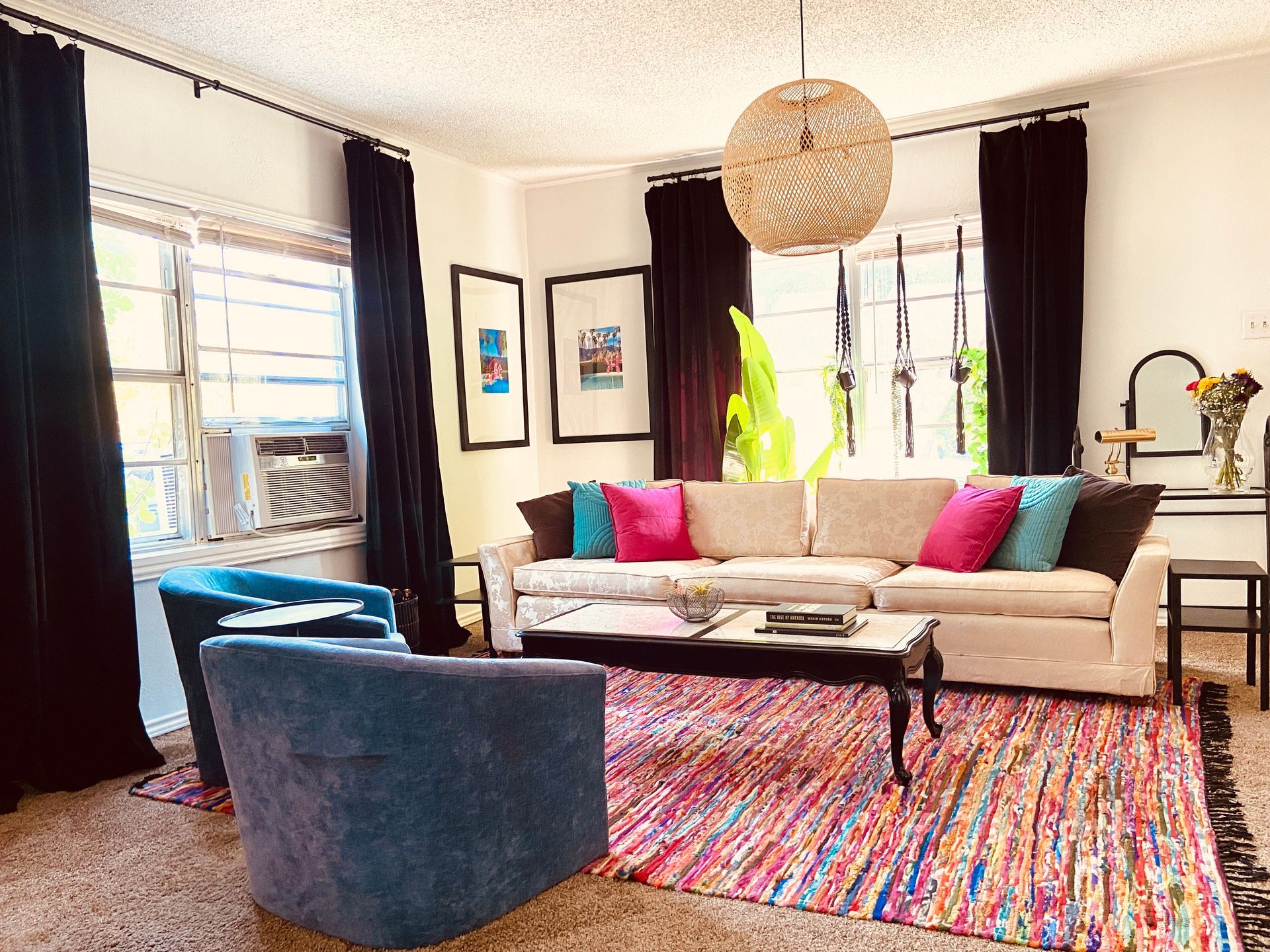 A living room with a couch , chairs , coffee table and rug