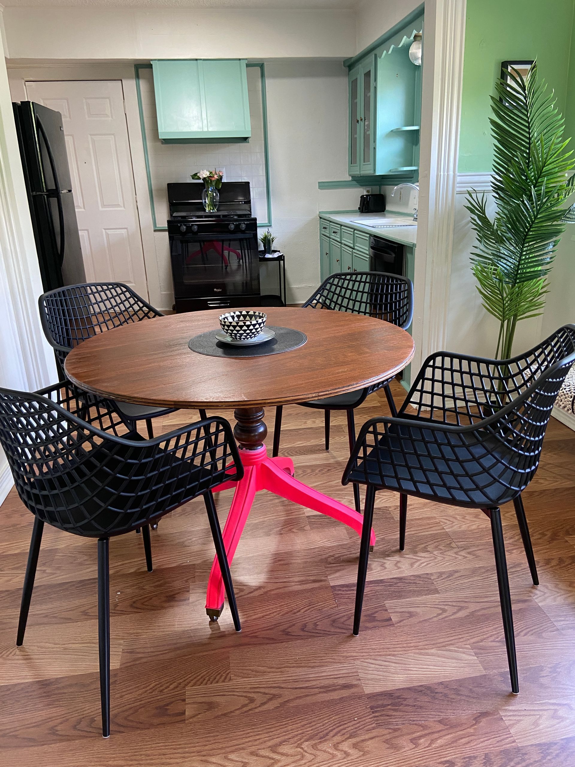 A dining room with a round table and four chairs.