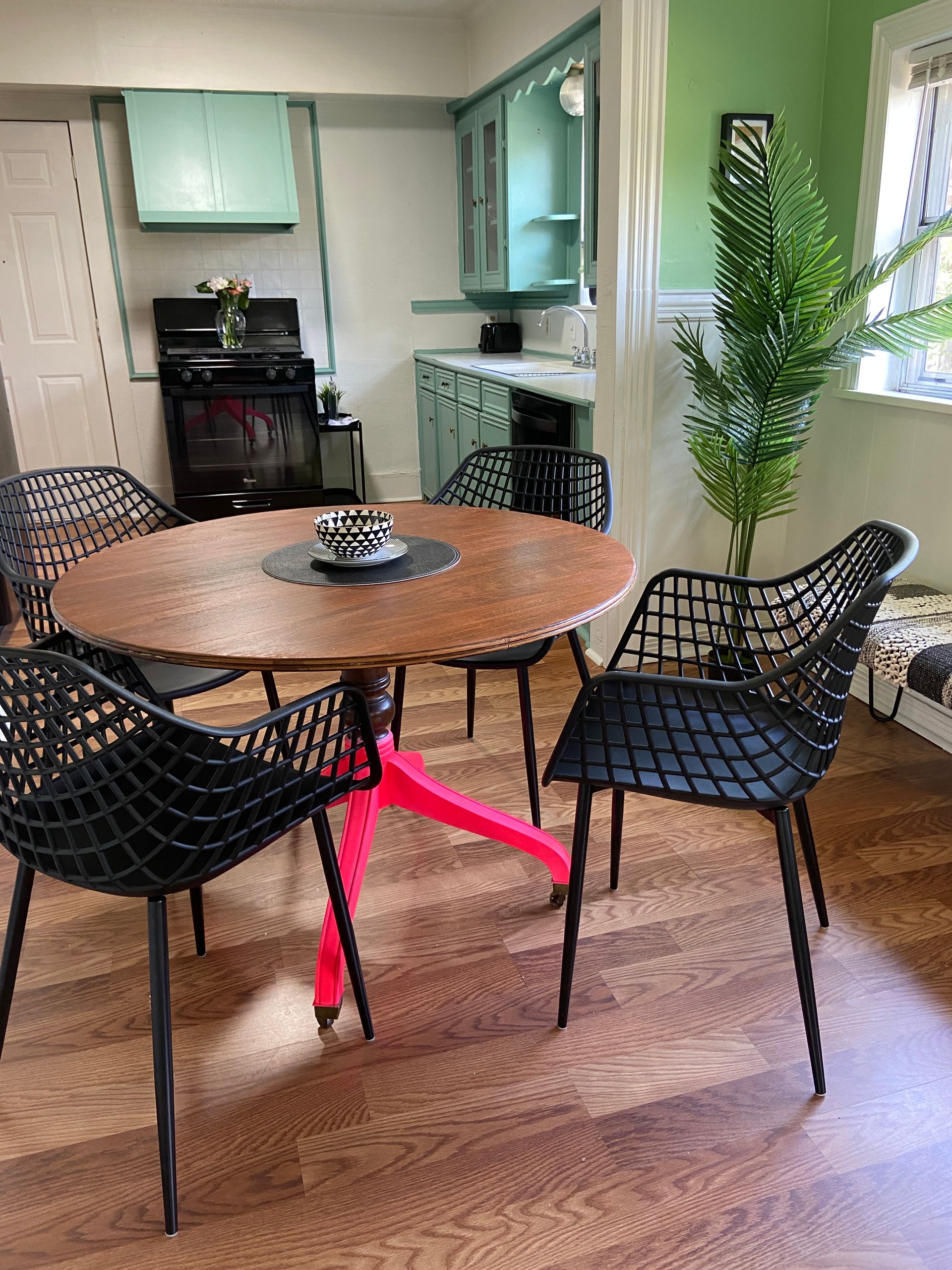 A dining room with a round table and chairs and a stove.