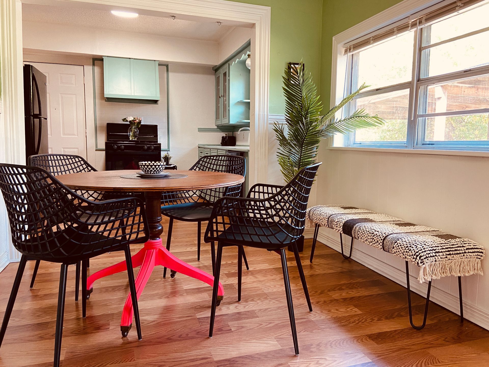 A dining room with a table and chairs and a bench.