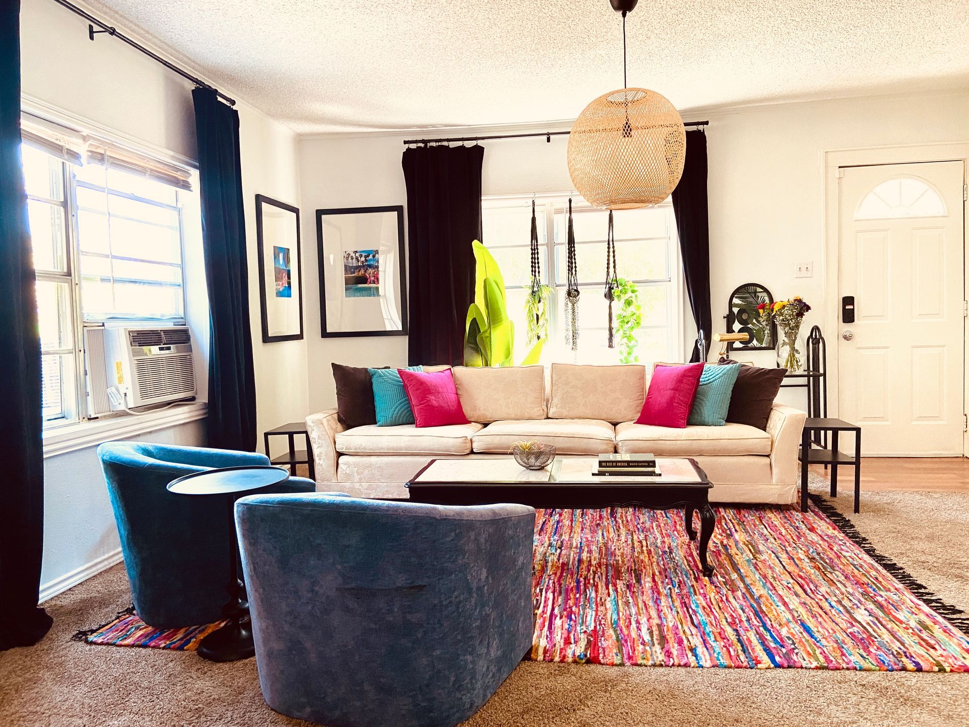 A living room with a couch , chairs , coffee table and rug.
