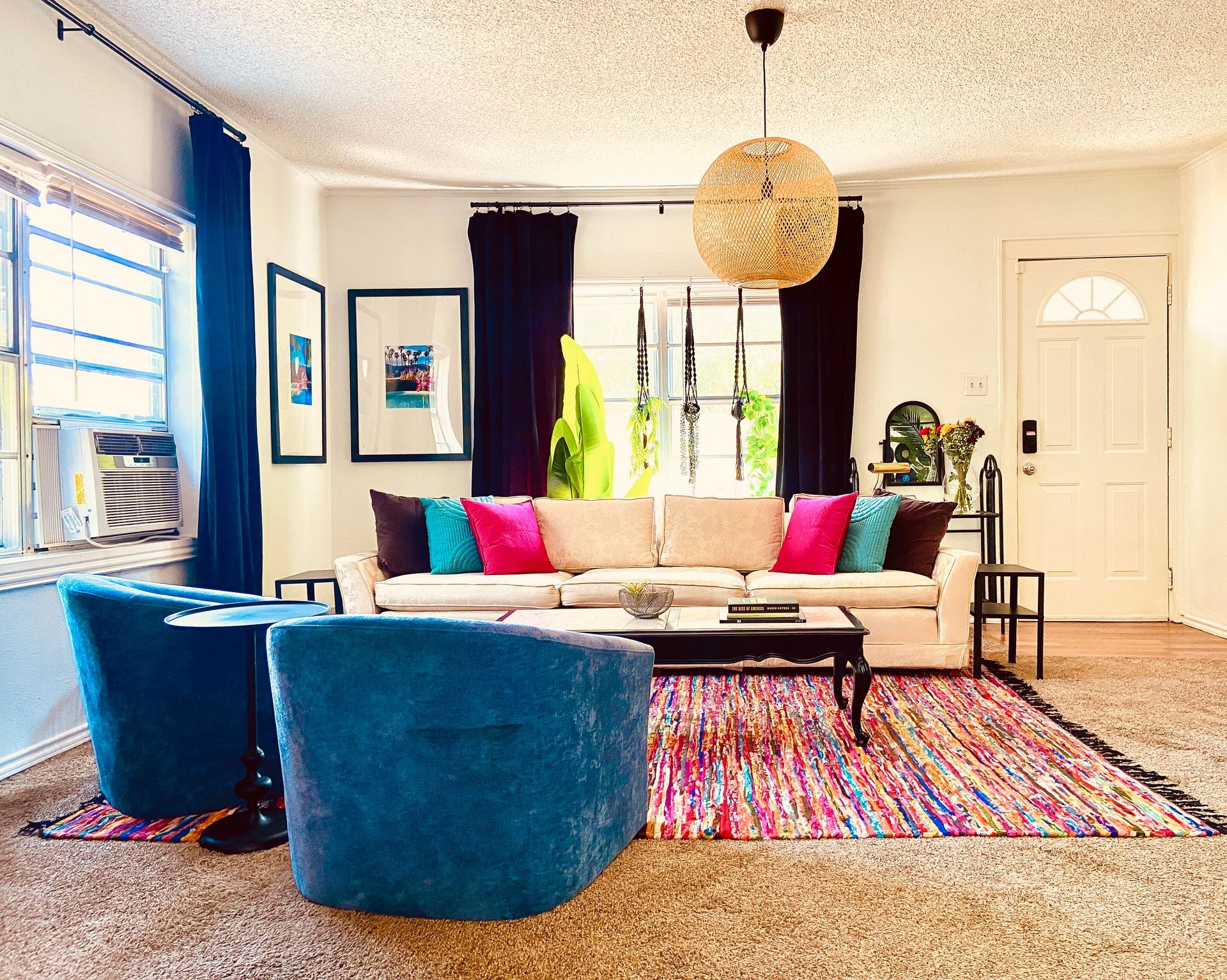 A living room with a couch two chairs and a rug