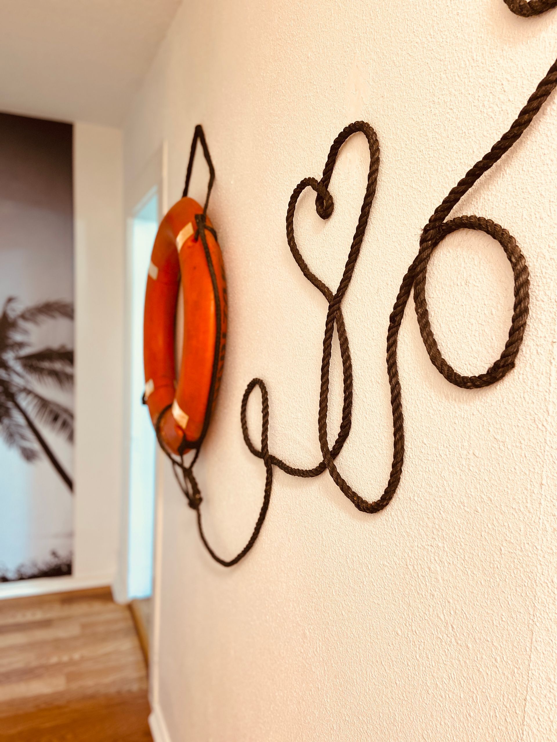 A life preserver is hanging on a wall next to the word life