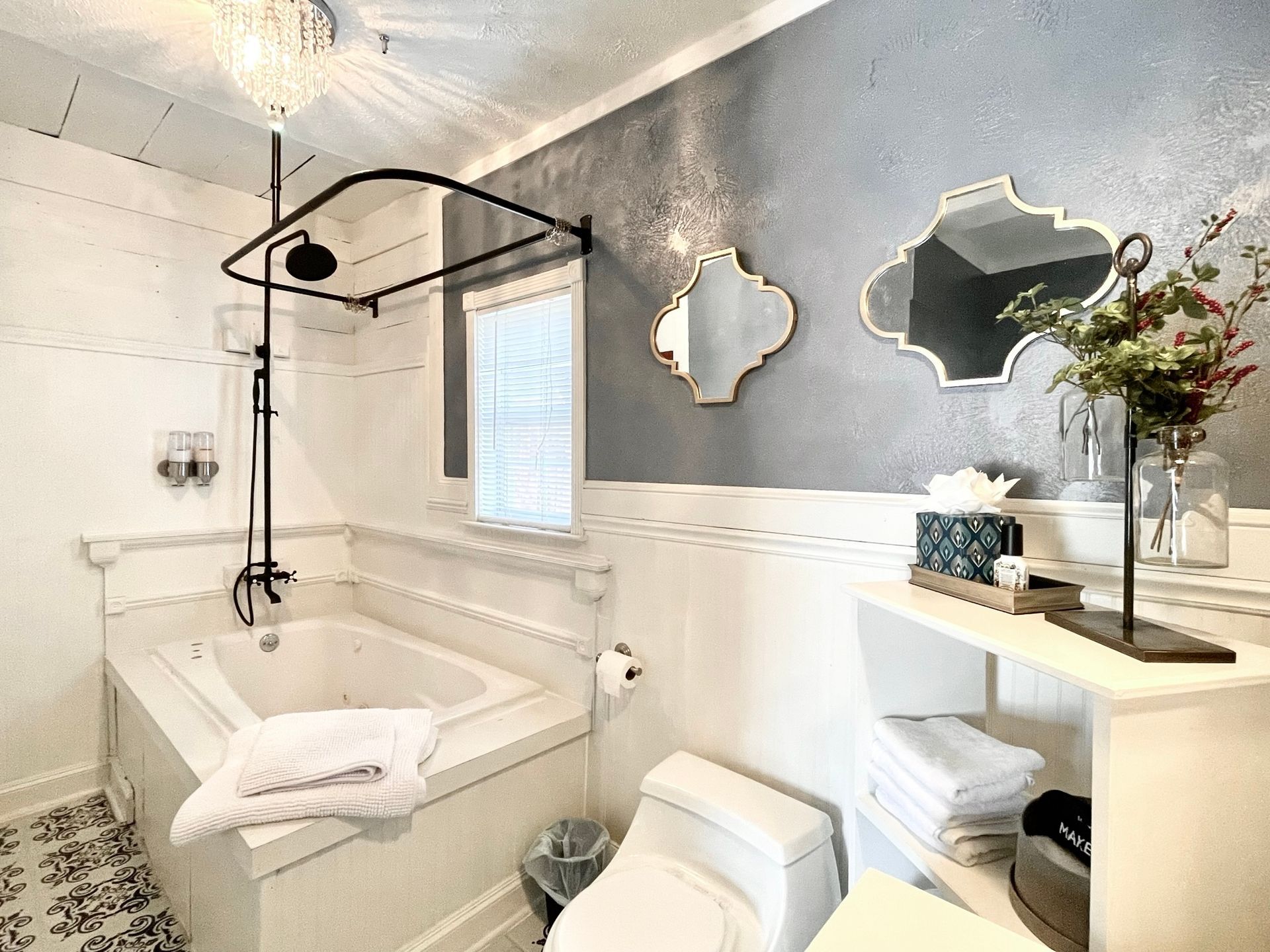 A bathroom with a tub , toilet , and mirror.