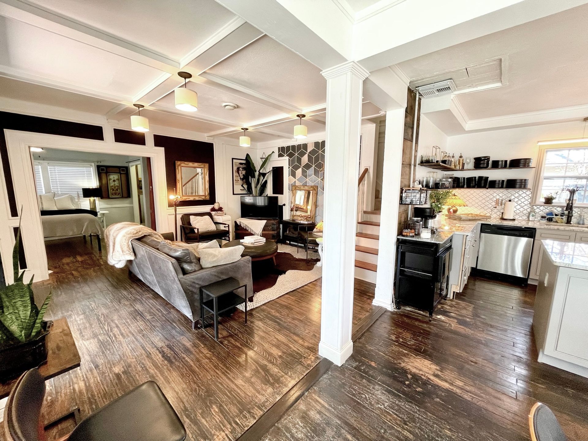 A living room filled with furniture and a kitchen in a house.