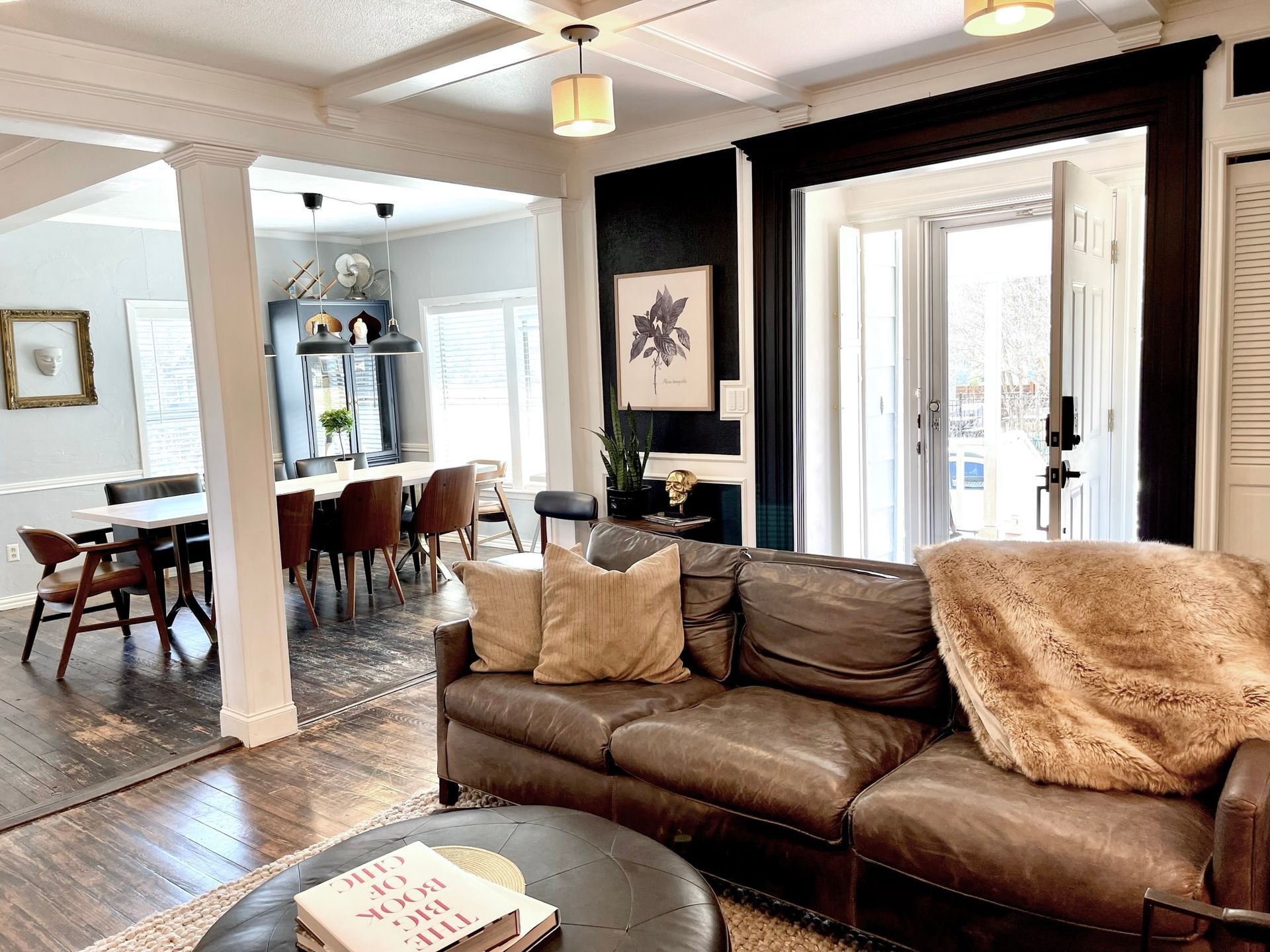 A living room with a couch , chair , table and ottoman.