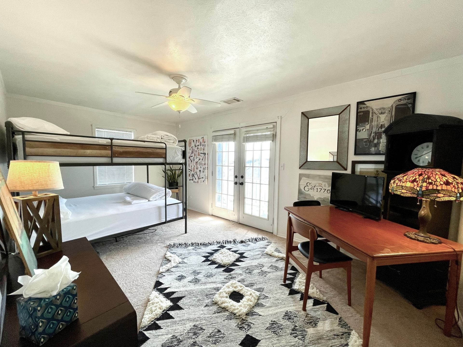 A bedroom with a bunk bed and a desk.