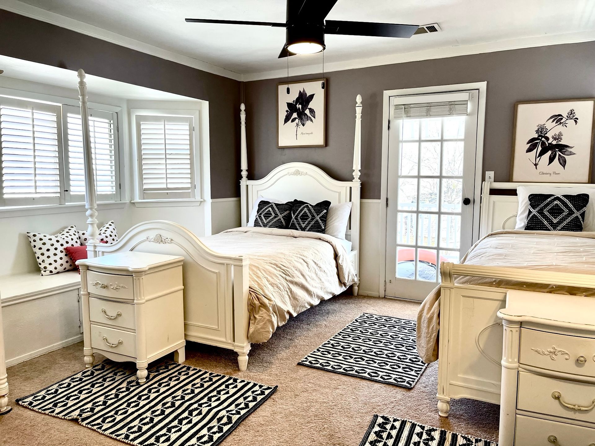 A bedroom with two beds and a ceiling fan.