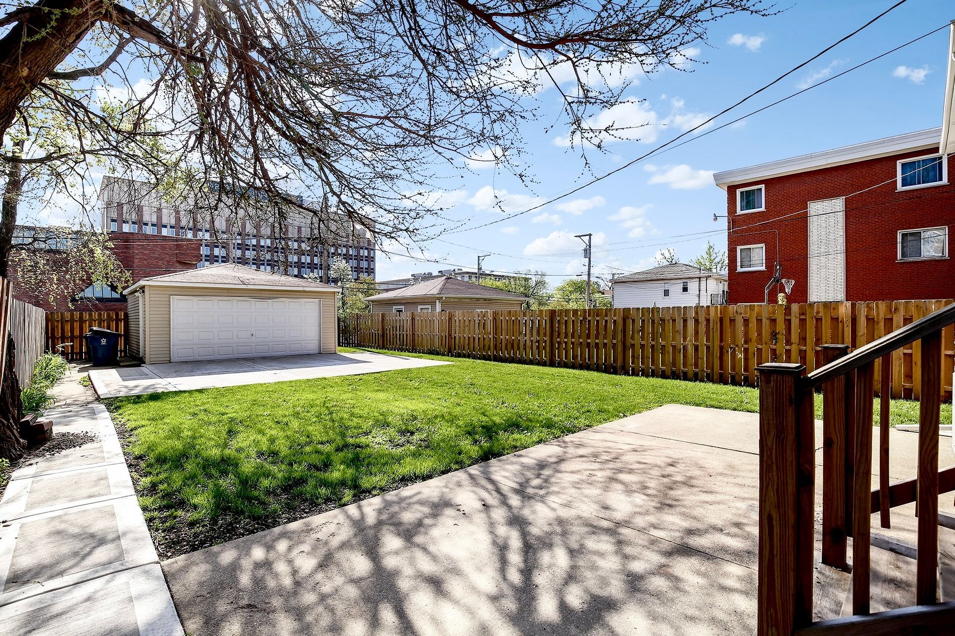 A backyard with a garage and a wooden fence
