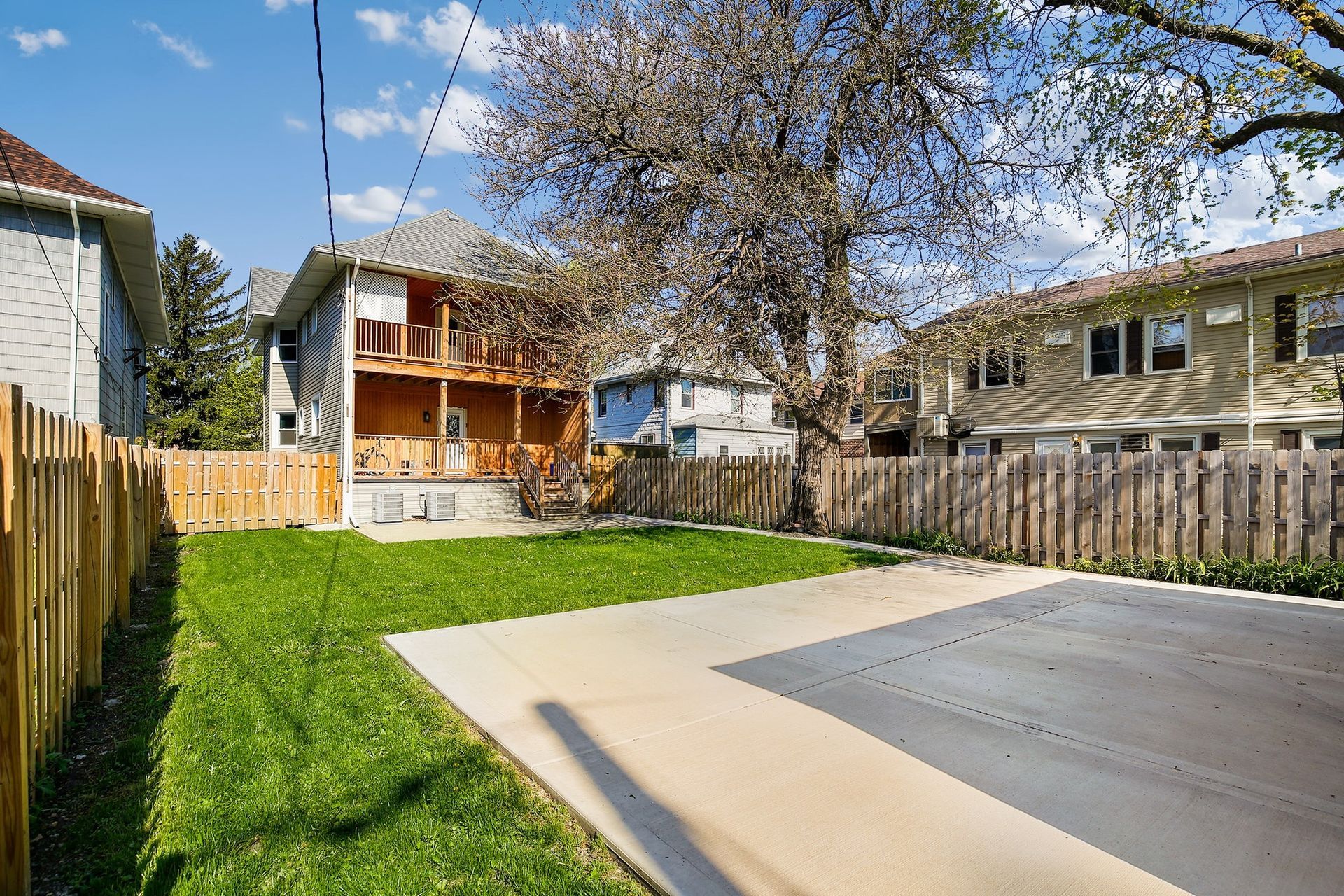 A driveway leading to a house with a wooden fence