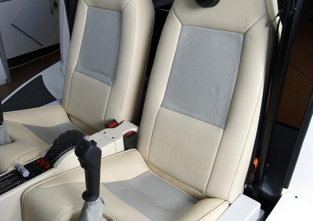 Sièges d'avion de couleur crème avec inserts gris et manche de commande noir.