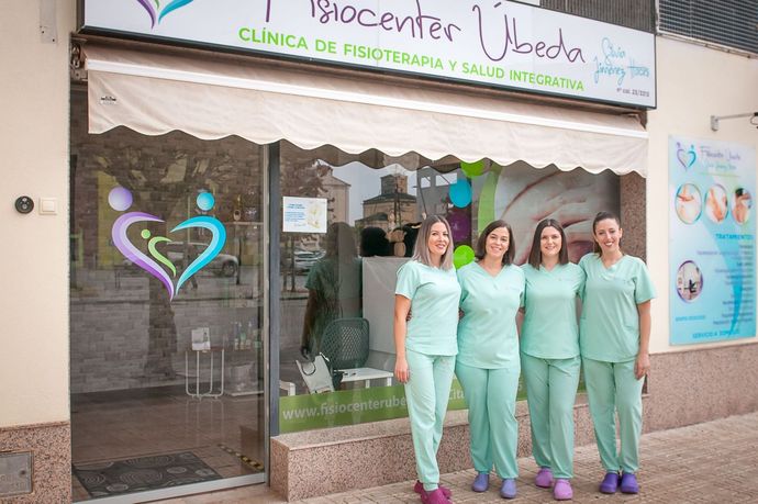 Un grupo de mujeres con uniforme médico posan para una fotografía frente a un edificio.