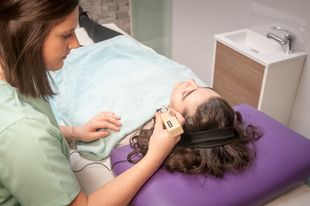 Una mujer está acostada sobre una almohada morada mientras una mujer está acostada en una cama.