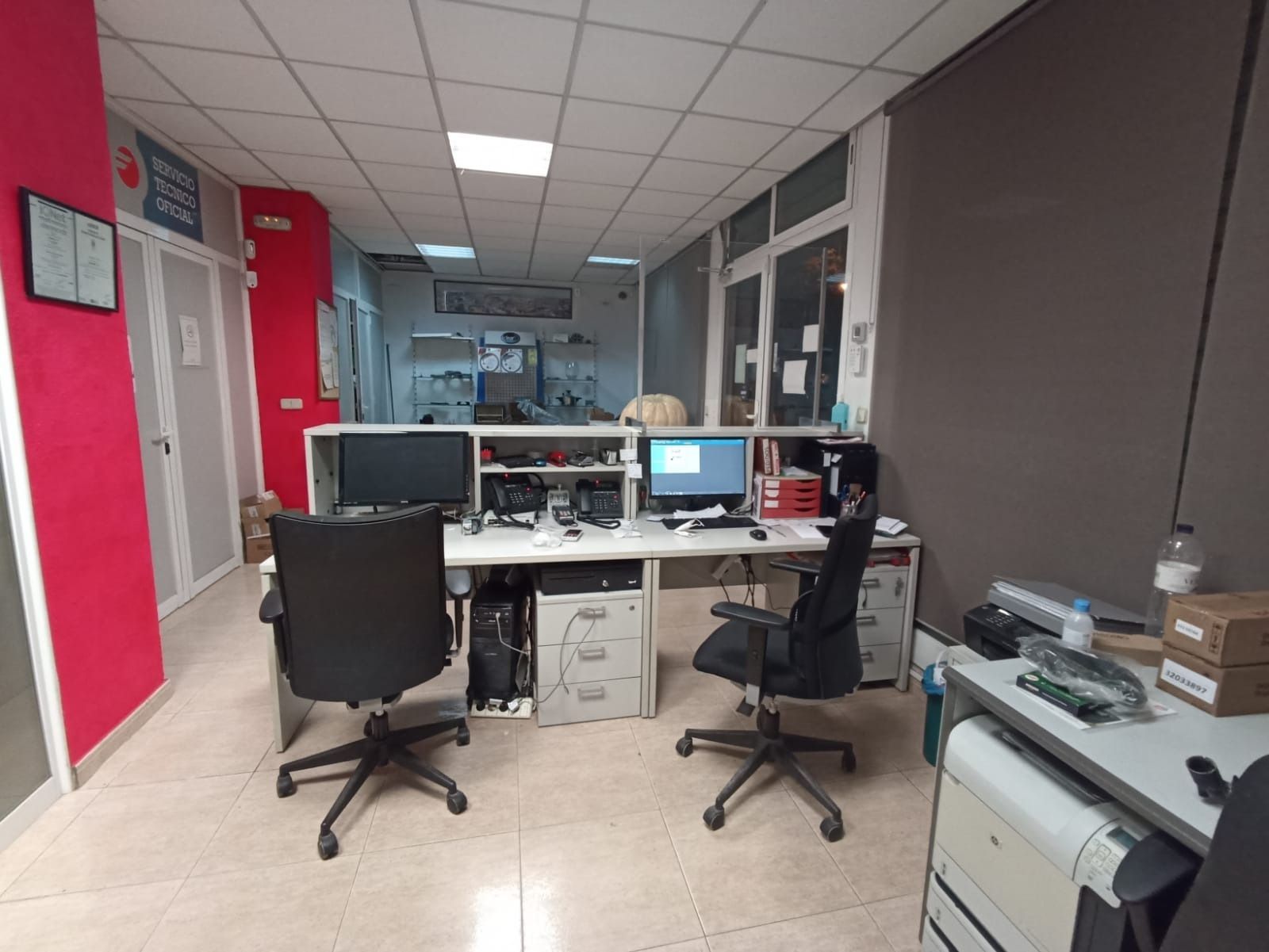 Una habitación con dos escritorios con computadoras y sillas.