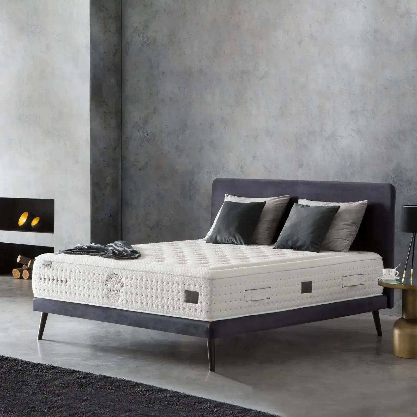 Dormitorio moderno con cama tapizada en gris, colchón blanco y decoración minimalista oscura.