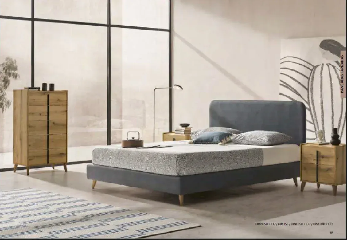 Dormitorio minimalista con cama gris, muebles de madera, grandes ventanales y un mural de plantas.