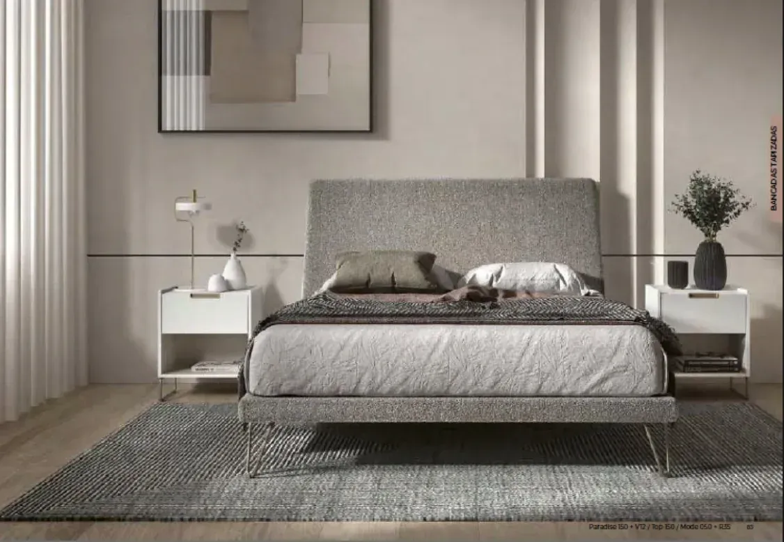 Dormitorio minimalista en tonos grises con cama, mesitas de noche, lámpara, alfombra y cuadro.