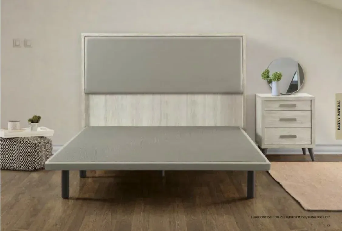 Dormitorio minimalista con cama gris, mesita de noche blanca y alfombra beige sobre suelo de madera.