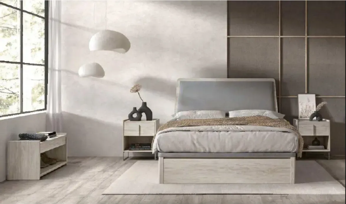 Dormitorio minimalista en color gris con una cama bien hecha, mesitas de noche, lámparas colgantes y una gran ventana.