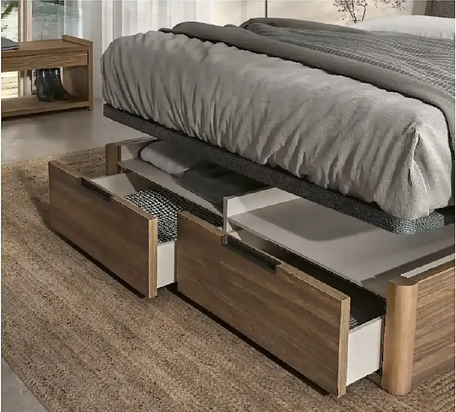 Estructura de cama de madera con cajones de almacenamiento, ropa de cama gris y un ambiente de dormitorio moderno.