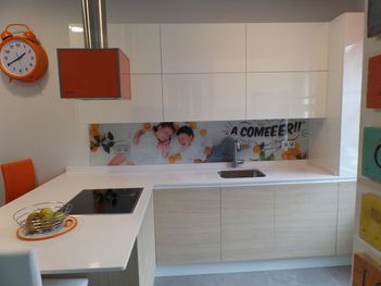 Una cocina con gabinetes blancos y un reloj en la pared.