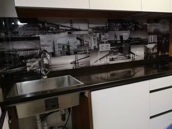 Una cocina con un fregadero y una imagen de una ciudad en la pared.