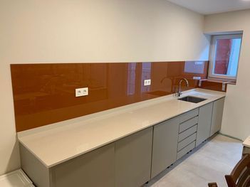 Una cocina con fregadero, armarios y una silla.