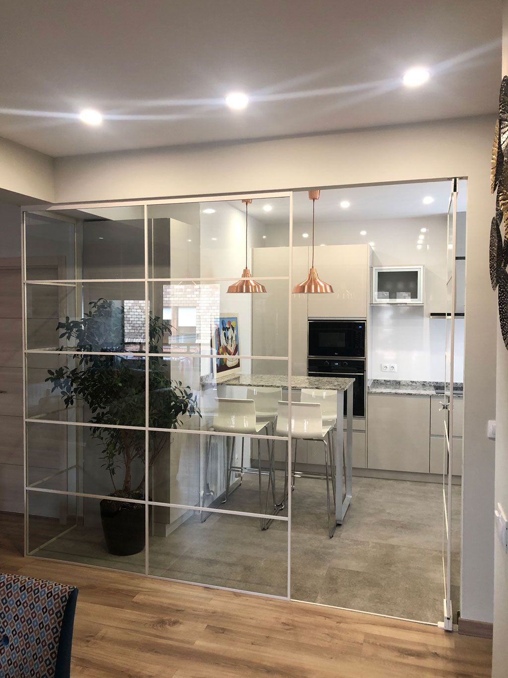 Una cocina con puertas corredizas de vidrio entre el comedor y la cocina.