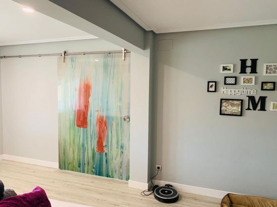 Una sala de estar con una puerta corrediza de vidrio y un cuadro en la pared.