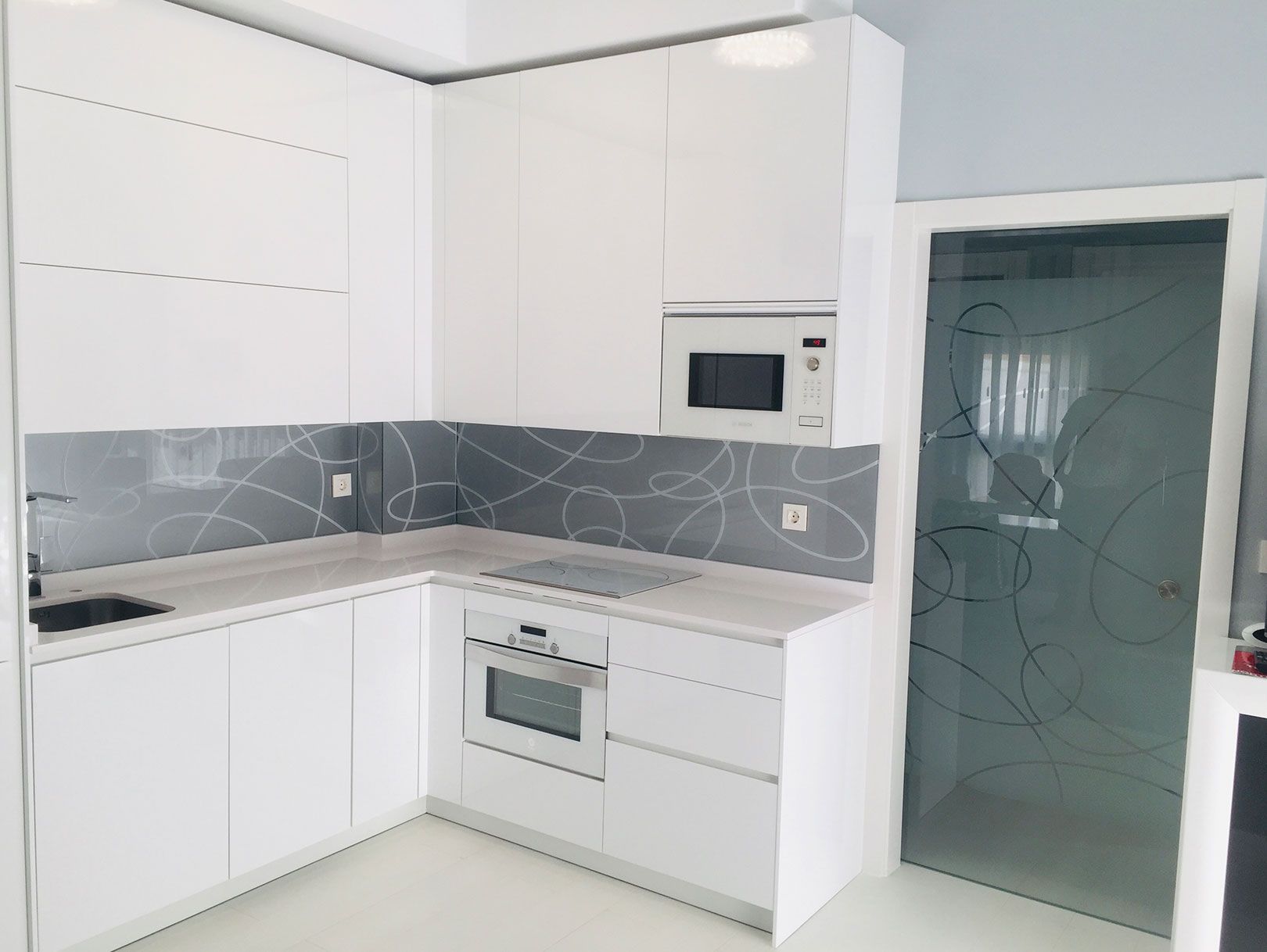 Una cocina con gabinetes blancos y un horno microondas.