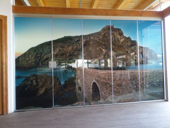 Hay una imagen de un puente en la pared detrás de las puertas de vidrio.
