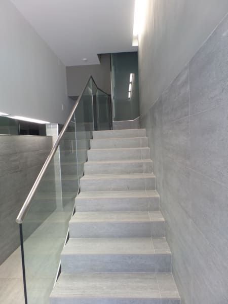 Un conjunto de escaleras con barandilla de cristal en un edificio.