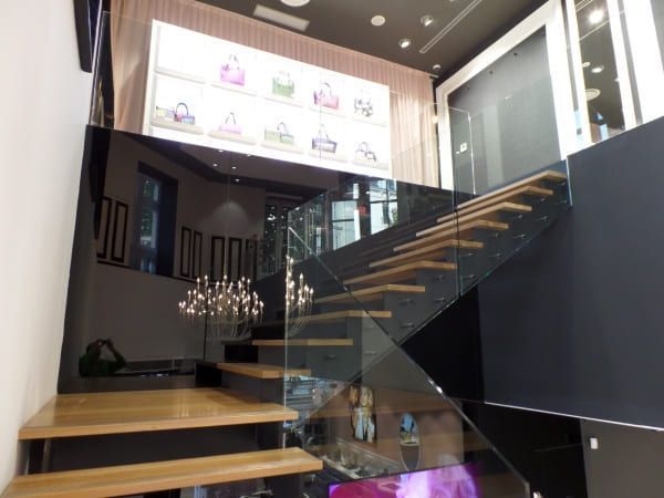 Una escalera en un edificio con barandilla de cristal.