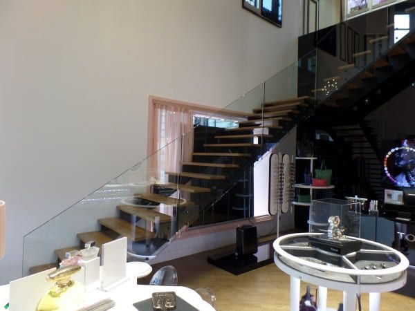 Una escalera en una habitación con barandilla de cristal.