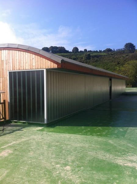 Un gran edificio con techo verde y techo de madera.