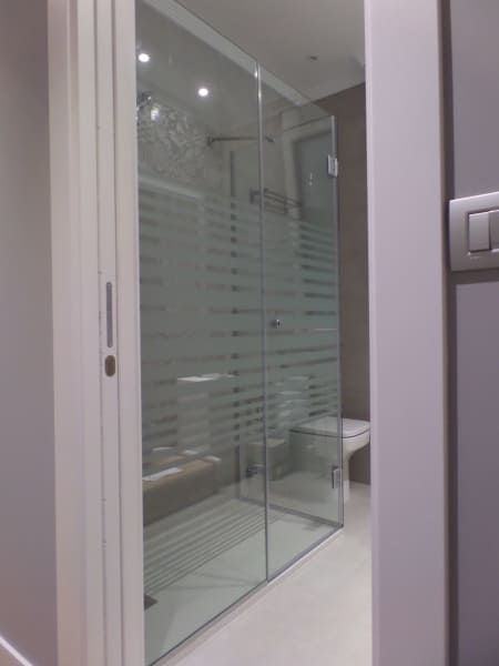 Un baño con ducha a ras de suelo y un aseo.