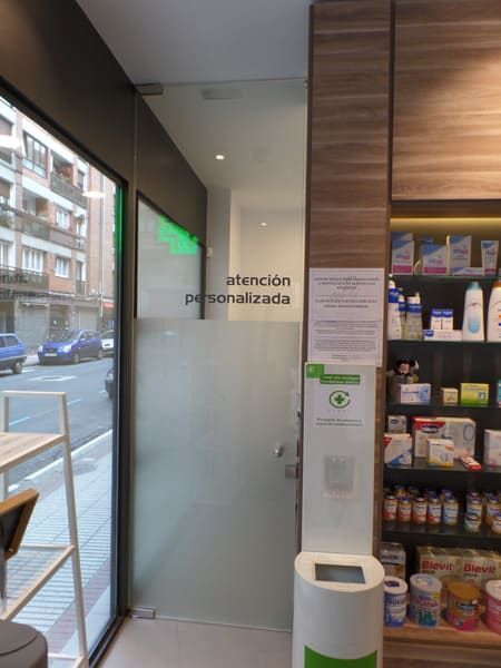 Una farmacia con un cartel que dice atención personalizada