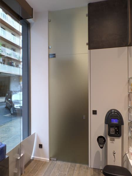 Una habitación con una puerta de cristal y un reloj en la pared.