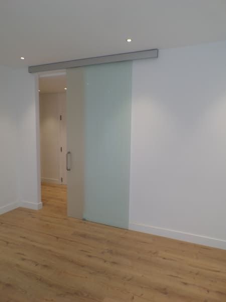 Una habitación vacía con una puerta corrediza de vidrio.