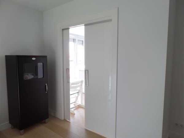 Una habitación con un armario negro y puertas corredizas que conducen a un comedor.