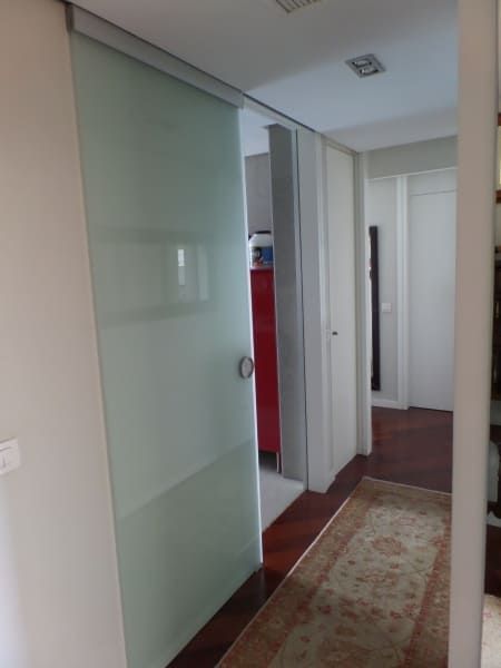 Un pasillo con una puerta corrediza de vidrio y una alfombra.
