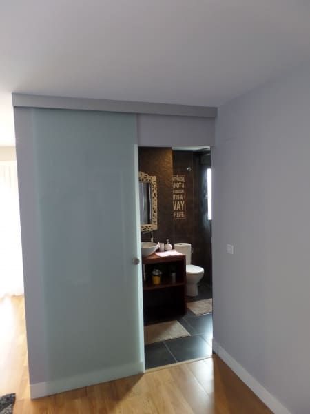 Una habitación con una puerta corrediza de vidrio que conduce a un baño.