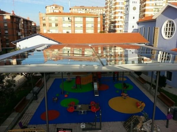 Una vista aérea de un parque infantil con edificios al fondo.
