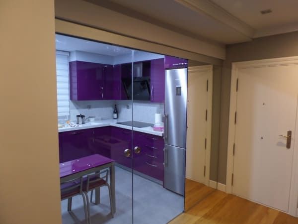 Una cocina con gabinetes morados y una puerta corrediza de vidrio.