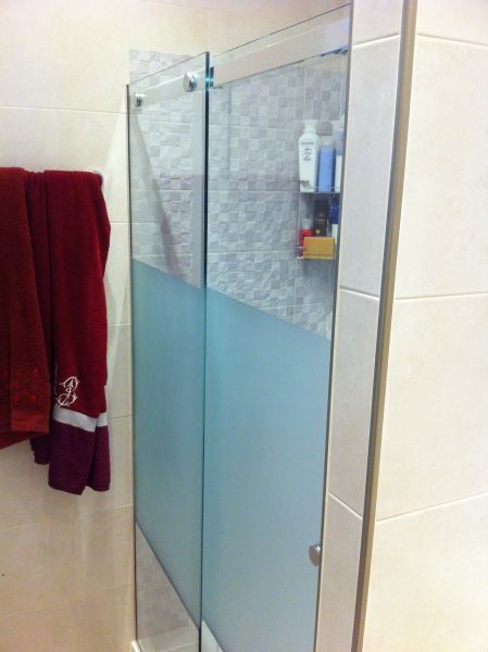 Un baño con una puerta de ducha corrediza de vidrio.