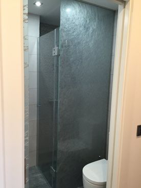 Un baño con inodoro y ducha a ras de suelo.