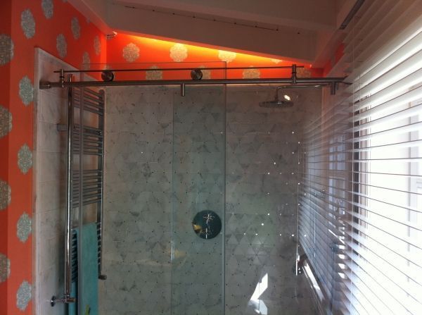 Un baño con ducha y una ventana con persianas.