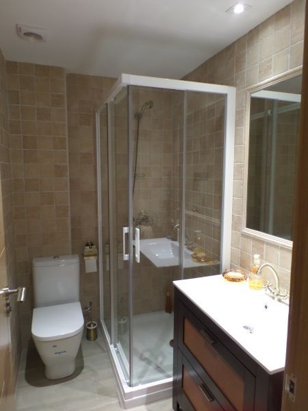 Un baño con inodoro, lavabo y ducha.