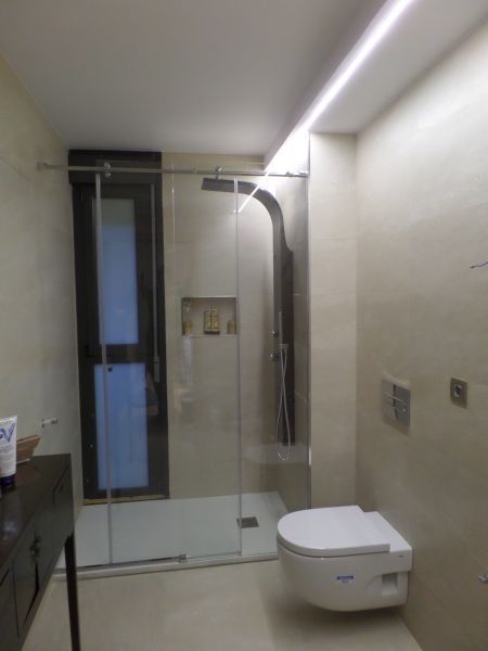 Un baño con inodoro y ducha a ras de suelo.